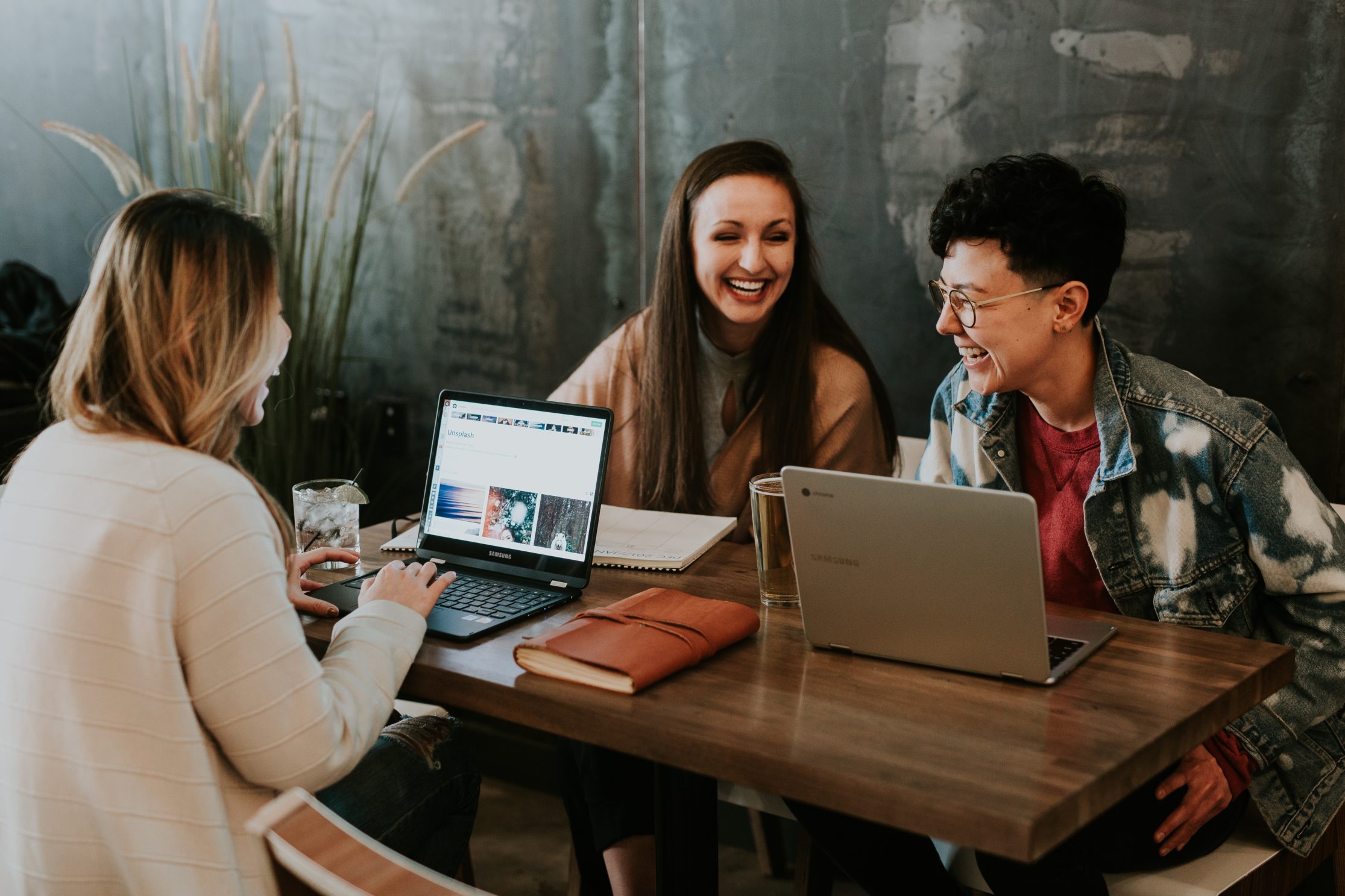 Des millenials, travaillant et rigolant assis autour une table